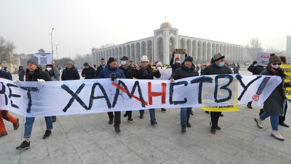 Люди держат плакат на митинге против новых конституционных поправок в Бишкеке - Sputnik Кыргызстан
