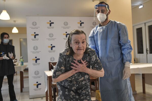 Женщина выражает благодарность после вакцинации от Covid-19 в доме престарелых в пригороде Афин, Греция - Sputnik Кыргызстан