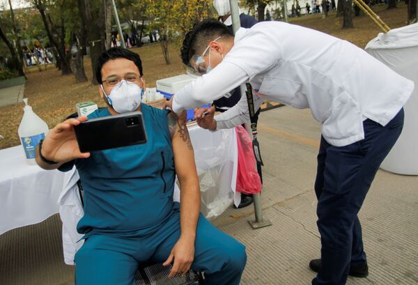 Медицинский работник делает селфи во время инъекции вакцины отCOVID-19 в военном госпитале в Сан-Николас-де-лос-Гарса, Мексика - Sputnik Кыргызстан