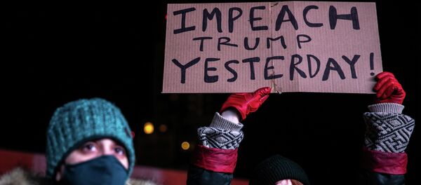 Женщина в защитной маске держит плакат во время митинга через день после штурма Капитолия сторонниками президента США Дональда Трампа Женщина в защитной маске держит плакат во время митинга через день после штурма Капитолия сторонниками президента США Дональда Трампа - Sputnik Кыргызстан