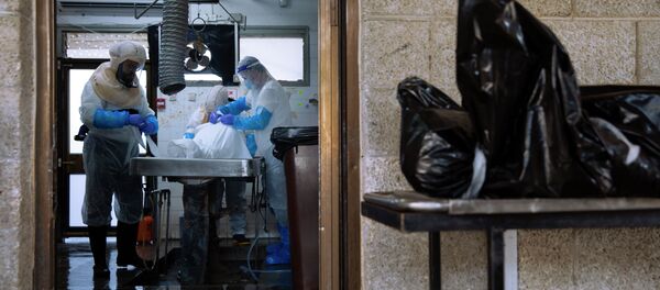Сотрудники погребального агентства готовят тело умершего от COVID-19. Архивное фото Сотрудники погребального агентства готовят тело умершего от COVID-19. Архивное фото - Sputnik Кыргызстан