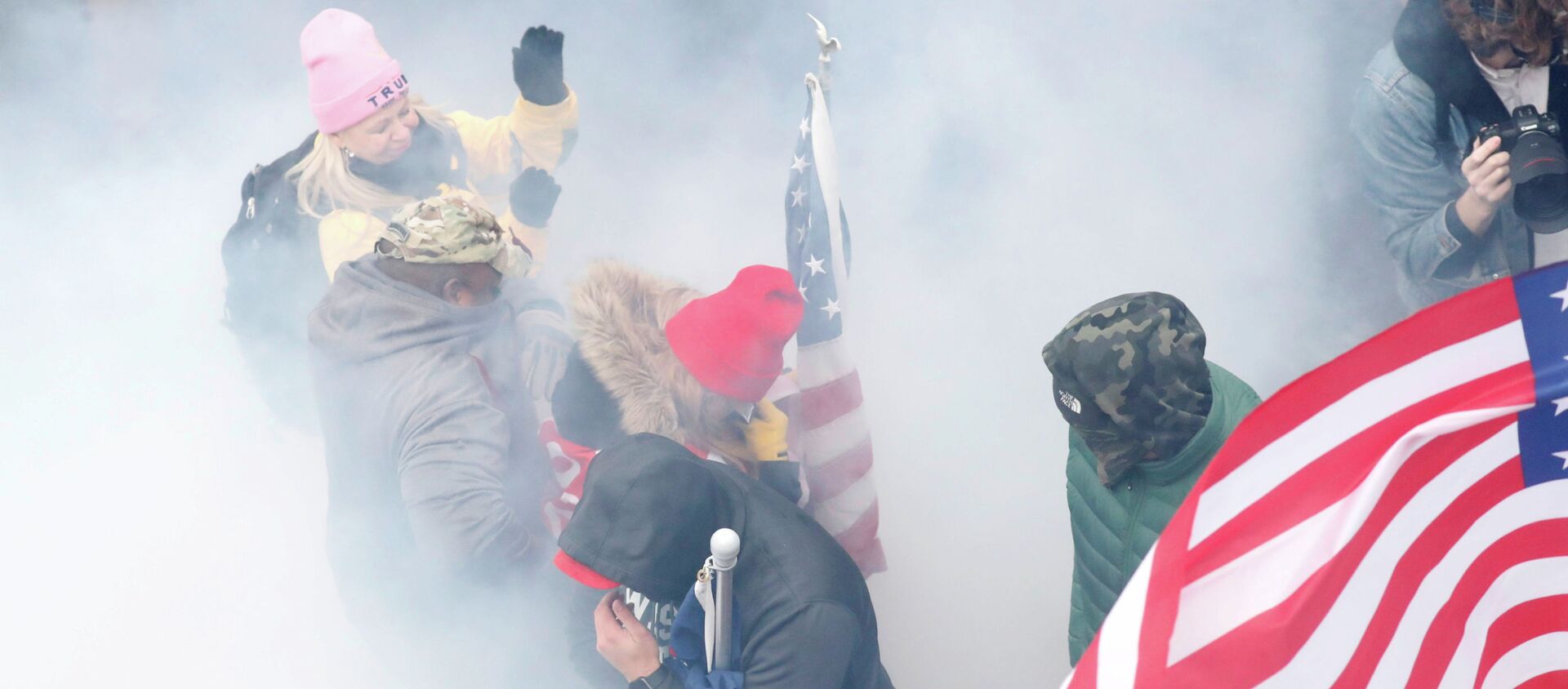 Протестующие, выступающие за Трампа в облаке слезоточивого газа во время столкновений с полицией у здания Капитолия в Вашингтоне - Sputnik Кыргызстан, 1920, 14.01.2021