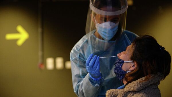 Медицинский работник берет у женщины образец мазка на COVID-19. Архивное фото - Sputnik Кыргызстан