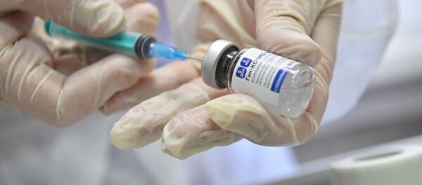 Медработник с вакциной Спутник V от коронавируса COVID-19 в прививочном пункте. Архивное фото - Sputnik Кыргызстан