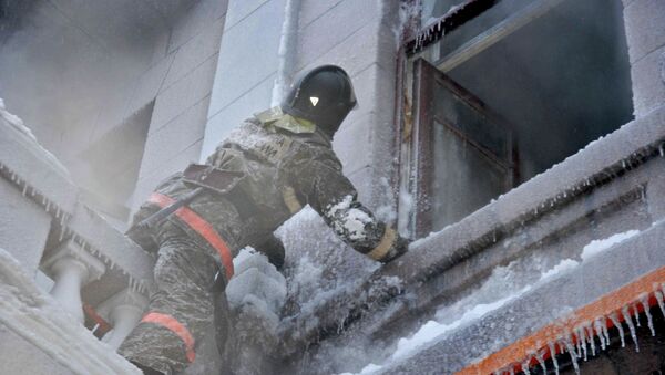 Пожарный осматривает помещение во время пожара. Архивное фото - Sputnik Кыргызстан
