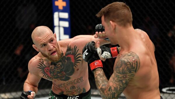 Конор МакГрегор из Ирландии наносит удар Дастину Порье в легком поединке во время мероприятия UFC 257  - Sputnik Кыргызстан