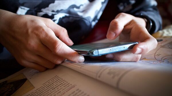 Подросток с телефоном в руке. Архивное фото - Sputnik Кыргызстан