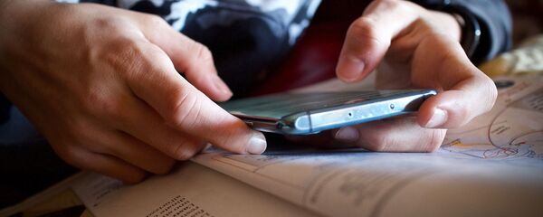 Подросток с телефоном в руке. Архивное фото Подросток с телефоном в руке. Архивное фото - Sputnik Кыргызстан