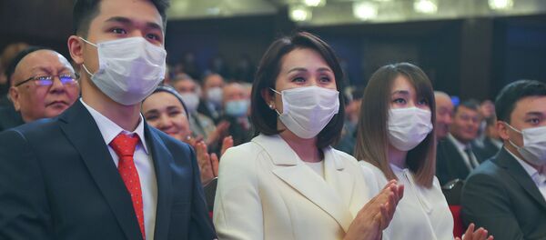 Сүрөттө Садыр Жапаровдун бет кап тагынган аялы Айгүл Асанбаеваны көрүүгө болот. Ал эми анын оң жагында уулу, сол жагында кызы Жанайым отурат. - Sputnik Кыргызстан