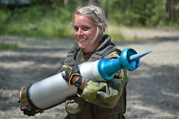 Женщина-военнослужащий армии Швеции несет снаряд во время танковых испытаний Strong Europe - Sputnik Кыргызстан