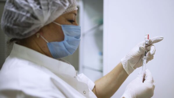 Медицинский работник набирает в шприц вакцину от COVID-19 - Sputnik Кыргызстан