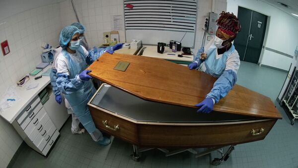 Медицинский персонал закрывает гроб с телом пациента, умершего от Covid-19, в морге больницы - Sputnik Кыргызстан