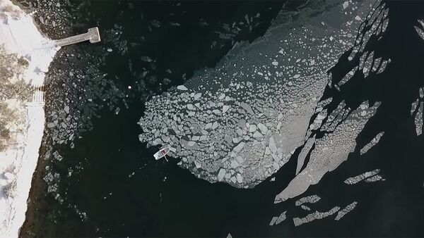 Мужчина в одиночку на лодке толкает льдину невероятных размеров. Видео - Sputnik Кыргызстан