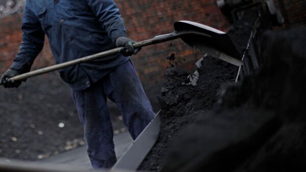 Рабочий - угольщик сгребает уголь. Архивное фото  - Sputnik Кыргызстан