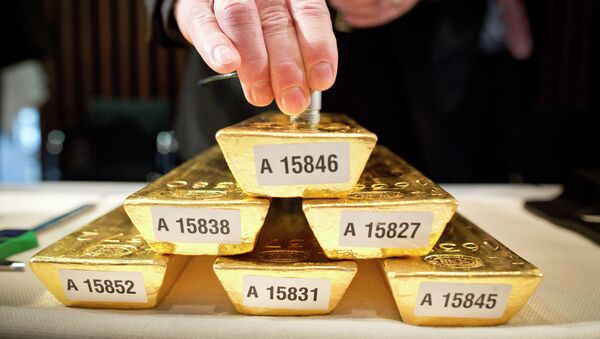 Сотрудник банка проверяет сердцевину золотого слитка. Архивное фото - Sputnik Кыргызстан