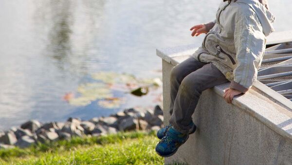 Мальчик сидит на берегу водоема. Архивное фото - Sputnik Кыргызстан