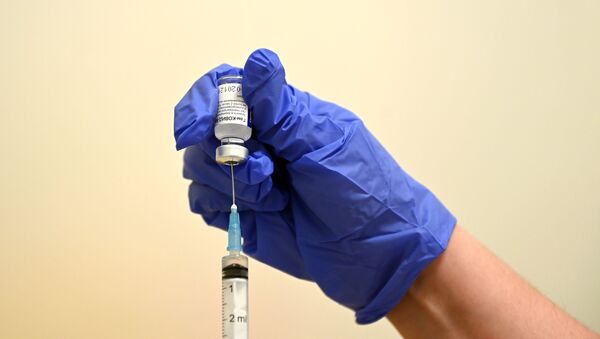 Медицинский сотрудник набирает в шприц вакцину Спутник V  - Sputnik Кыргызстан