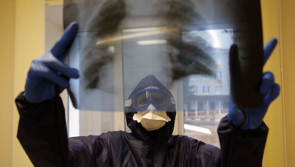 Медицинский работник в ковид-госпитале смотрит на рентген-снимок легких пациента. Архивное фото - Sputnik Кыргызстан