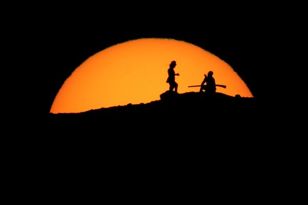 АКШнын Аризона штатынын Финикс шаарындагы Папагайо паркындагы чокудан саякатчылар күндүн батып бара жатканын карап турушат - Sputnik Кыргызстан