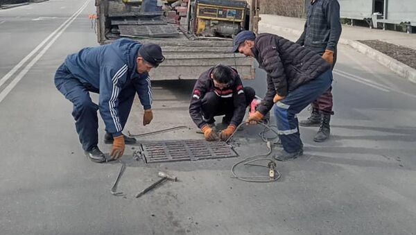 Сотрудники МП Бишкекасфальтсервис закрывают открытый люк в Бишкеке - Sputnik Кыргызстан