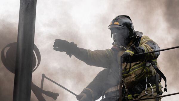 Сотрудник пожарной части во время тушения огня. Архивное фото - Sputnik Кыргызстан