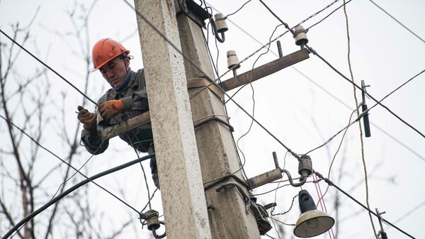 Сотрудник Северэлектро проводит ремонтные работы на линии электропередач. Архивное фото - Sputnik Кыргызстан