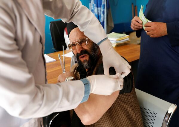 Работник больницы во время вакцинации AstraZeneca в Кабуле, Афганистан  - Sputnik Кыргызстан