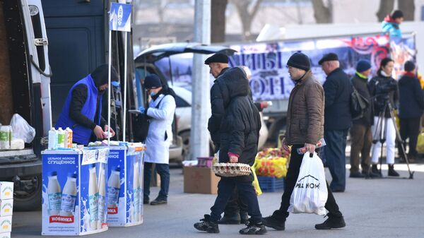 Люди покупают товары на сельскохозяйственной ярмарке в Бишкеке. Архивное фото - Sputnik Кыргызстан