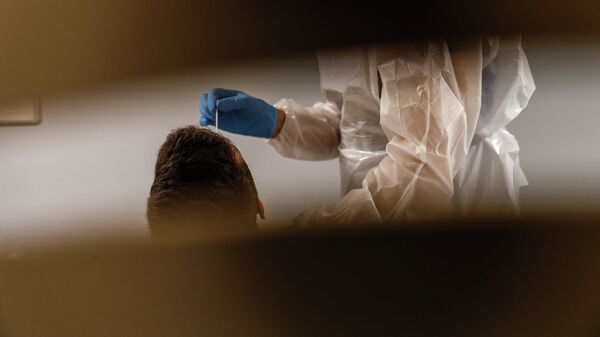 Медик берет образец из носа с мазком у у человека. Архивное фото - Sputnik Кыргызстан