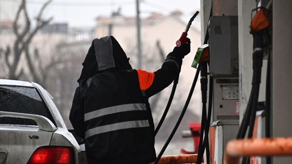 Сотрудник АЗС во время заправки автомобиля. Архивное фото - Sputnik Кыргызстан