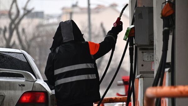 Работник АЗС заправляет автомобиль - Sputnik Кыргызстан