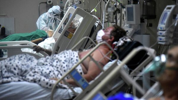 Медицинский работник оказывает помощь пациенту с COVID-19 в больнице - Sputnik Кыргызстан