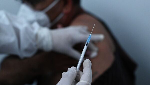 Медициналык кызматкер COVID-19дан каршы эмдөө учурунда. Архив - Sputnik Кыргызстан