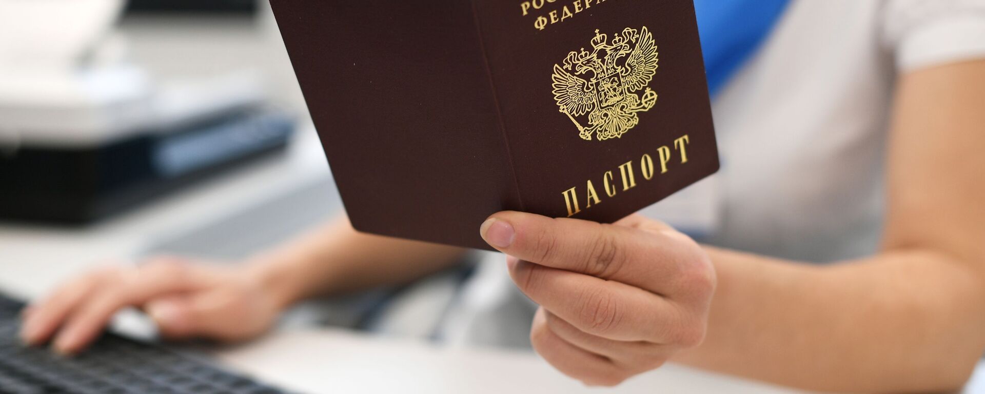 Государственный служащий держит в руках паспорт РФ - Sputnik Кыргызстан, 1920, 25.03.2021