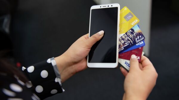 Смартфон и банковские карточки в руках у девушки. Иллюстративное фото - Sputnik Кыргызстан