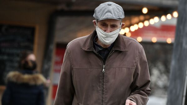 Мужчина в маске идет по улице. Архивное фото - Sputnik Кыргызстан