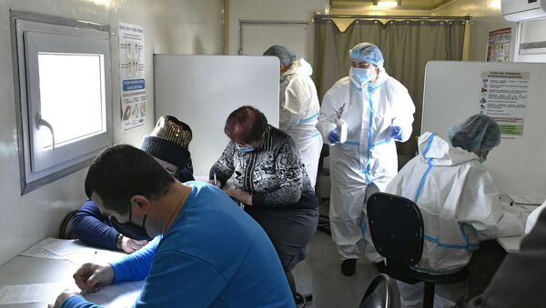 Люди заполняют анкеты перед вакцинацией от COVID-19 вакциной Спутник-V (Гам-КОВИД-Вак) в мобильном пункте в Краснодаре. - Sputnik Кыргызстан
