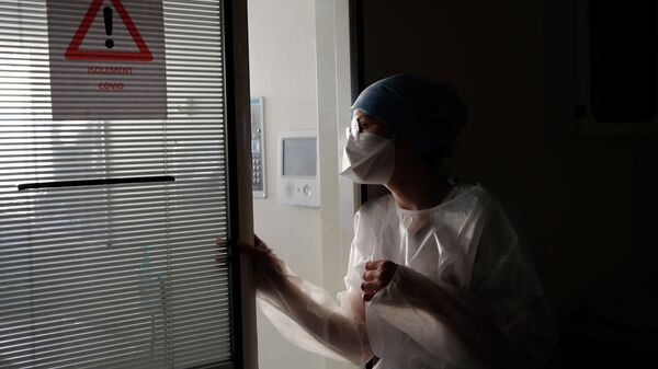 Медицинский работник осматривает пациента с COVID-19 в больнице. Архивное фото - Sputnik Кыргызстан