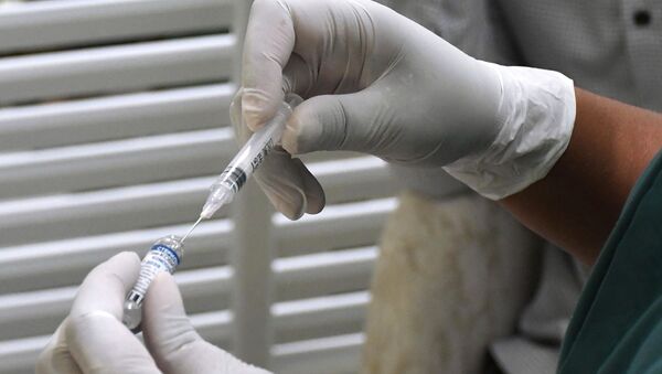 Медицинский работник набирает в шприц вакцину от COVID-19. Архивное фото - Sputnik Кыргызстан