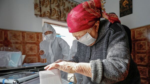 Женщина опускает бюллетень в урну во время досрочного голосования на выборах в местные кенеши и референдум по проекту новой Конституции в Кыргызстане - Sputnik Кыргызстан