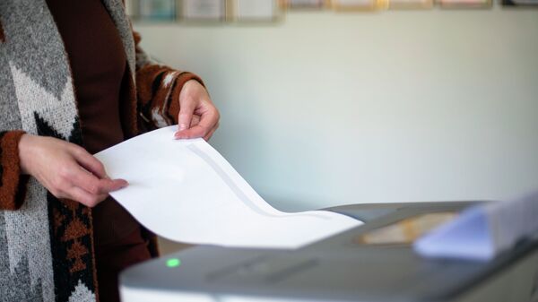 Женщина голосует на избирательном участке №1219 в Бишкеке во время выборов в местные кенеши и референдум по проекту новой Конституции. - Sputnik Кыргызстан