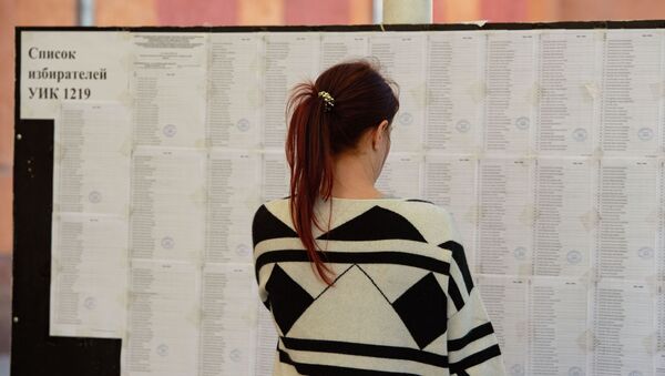 Девушка смотрит список избирателей на участке в Бишкеке. Архивное фото - Sputnik Кыргызстан