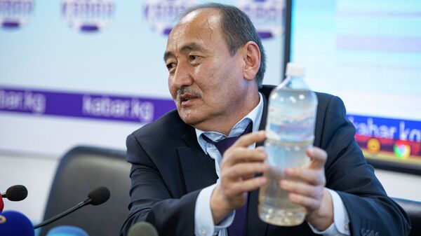 Министр здравоохранения Алымкадыр Бейшеналиев показывает бутылку с настойкой иссык-кульского корня - Sputnik Кыргызстан