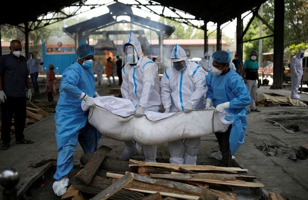 Медицинские работники и родственники несут тело мужчины, умершего от коронавируса в Нью-Дели - Sputnik Кыргызстан