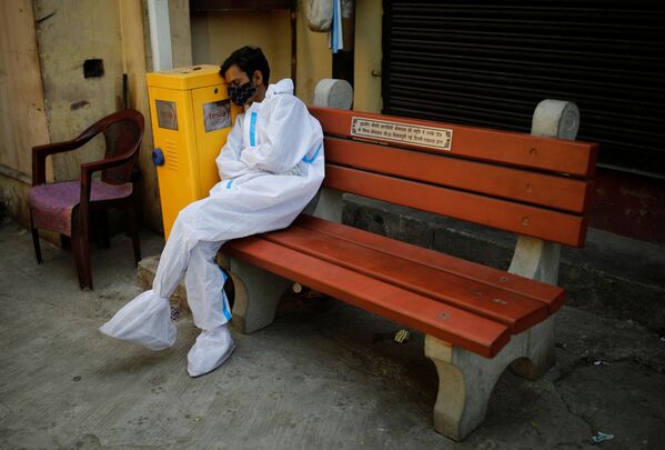 Обессиленный медицинский работник отдыхает в крематории в Нью-Дели, Индия - Sputnik Кыргызстан