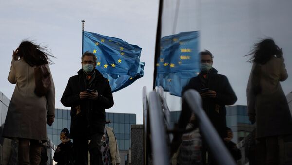 Люди в защитных масках на фоне флагов Евросоюза. Архивное фото - Sputnik Кыргызстан