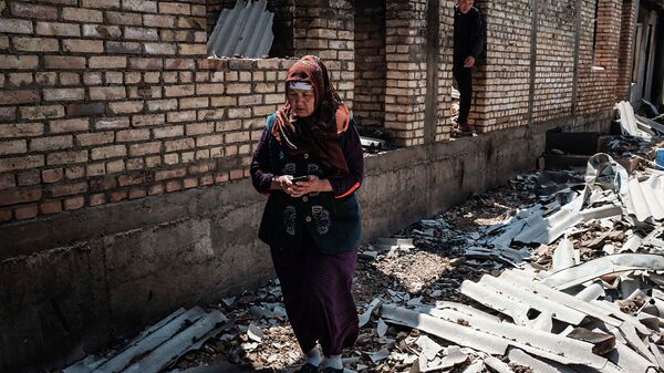 Женщина перед разрушенным домом в Баткенской области. Архивное фото - Sputnik Кыргызстан