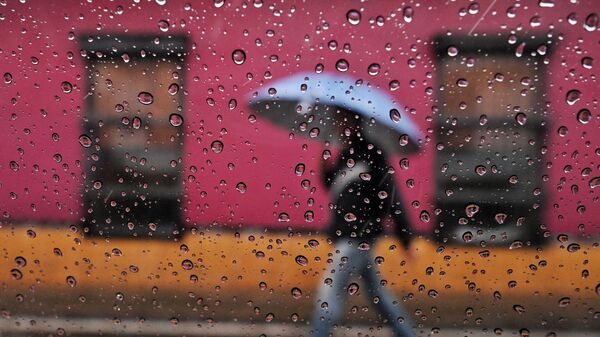Мужчина с зонтом под дождем. Архивное фото - Sputnik Кыргызстан