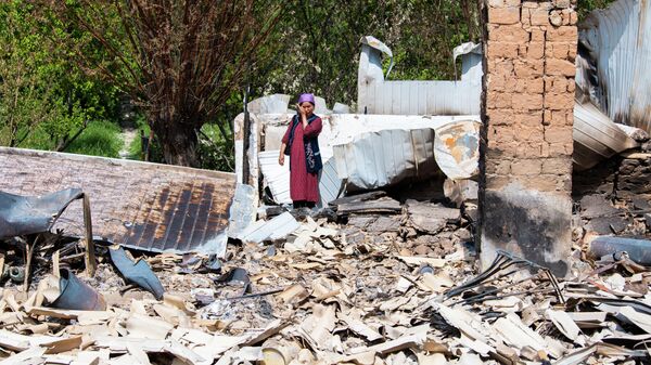 Жительница села Максат Лейлекского района возле своего дома, сгоревшего в ходе приграничного конфликта между Кыргызстаном и Таджикистаном - Sputnik Кыргызстан