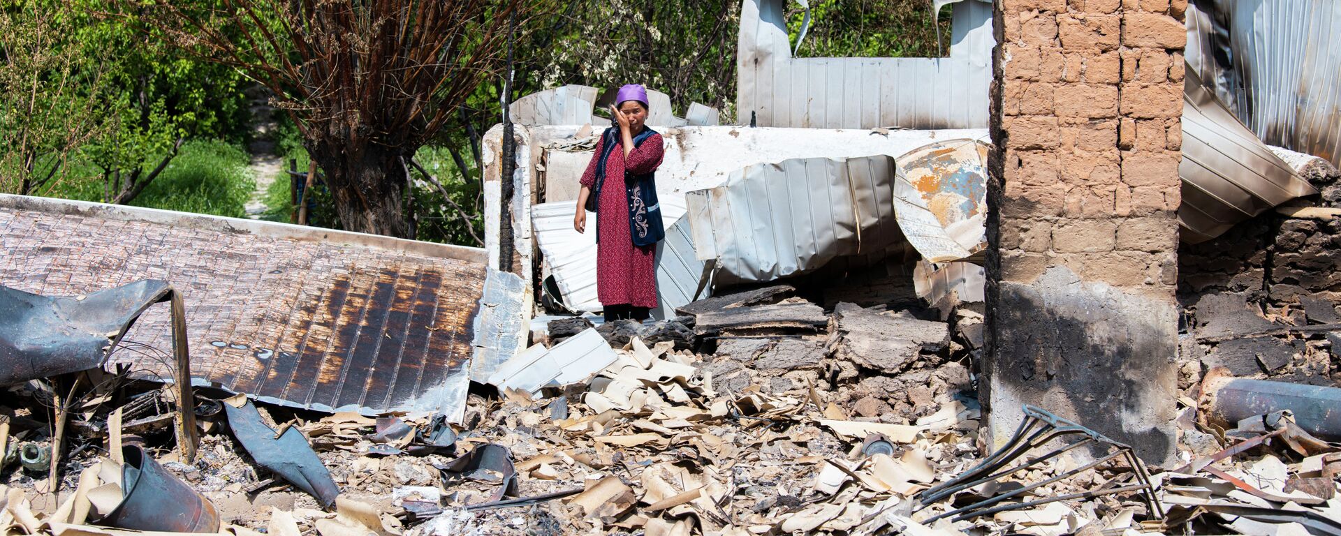 Жительница села Максат Лейлекского района возле своего дома, сгоревшего в ходе приграничного конфликта между Кыргызстаном и Таджикистаном - Sputnik Кыргызстан, 1920, 10.02.2022
